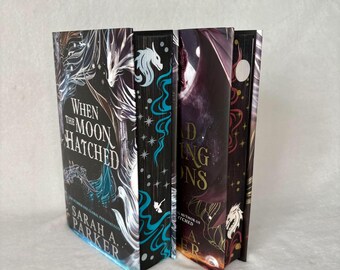 May include: Four hardcover books with fantasy-themed covers. The spines feature titles like "When the Moon Hatched" and "Finding Dragons." The covers showcase illustrations of dragons, celestial bodies, and intricate designs in shades of black, teal, and gold. The author's name is visible.