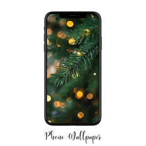 May include: A black smartphone displays a Christmas tree wallpaper. The wallpaper features a close-up of green pine needles and blurred golden lights. The words "Phone Wallpaper" are written in cursive at the bottom.