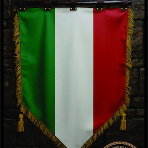 Peut inclure: Une bannière décorative aux couleurs du drapeau italien : vert, blanc et rouge. La bannière est bordée de franges et de glands dorés. Elle est suspendue à une tringle noire avec des lanières de cuir marron. La bannière porte un logo Viking.