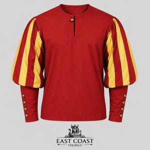 Puede incluir: Túnica roja con mangas a rayas amarillas. Las mangas largas tienen botones dorados en la muñeca. La túnica tiene una pequeña abertura en el cuello y un botón dorado. El logotipo de East Coast Vikings está en la parte inferior.