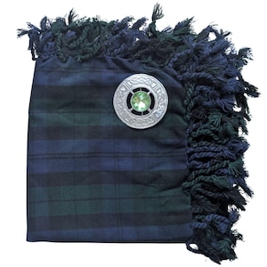 May include: A tartan plaid sash in navy blue and green with a decorative silver brooch. The brooch has a green gemstone center and an intricate Celtic knot design. The sash has a fringed edge in navy and green.