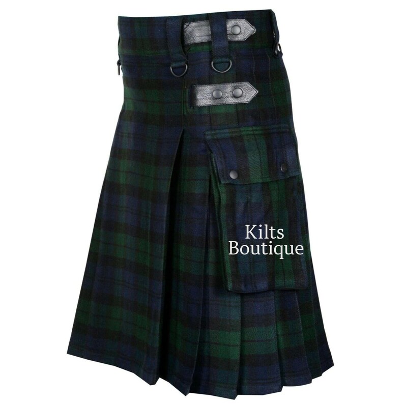 May include: A green and navy blue plaid kilt with leather accents and a pocket. The kilt has pleats and adjustable straps. The text "Kilts Boutique" is visible on the pocket.
