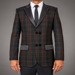 Puede incluir: Una chaqueta a cuadros marrón y verde con solapas y detalles de bolsillo negros. La chaqueta cruzada tiene botones negros y se usa con una camisa blanca y una corbata negra. Un estilo clásico.