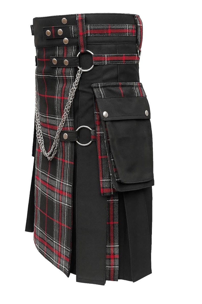 Może przedstawiać: Czarny kilt z czerwono-szarymi akcentami w kratę. Posiada łańcuch, metalowe pierścienie i kieszenie. Kilt ma plisowany design i strukturalny pas z srebrnymi elementami.