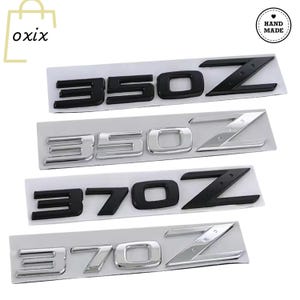 Peut inclure: Quatre badges d'emblème de voiture : deux noirs et deux argentés. Les badges indiquent "350Z" et "370Z". Les badges "350Z" sont noirs et argentés. Les badges "370Z" sont noirs et argentés. Les badges sont sur fond blanc.