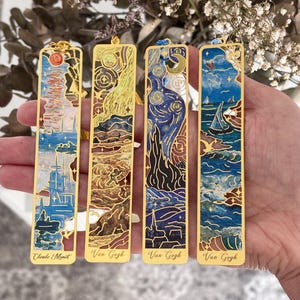 Op de afbeelding: Vier goudkleurige metalen bladwijzers met kleurrijke kunstdrukken. De bladwijzers tonen kunst van Claude Monet en Van Gogh. Elke bladwijzer heeft een kwast en is rechthoekig met een decoratieve rand.