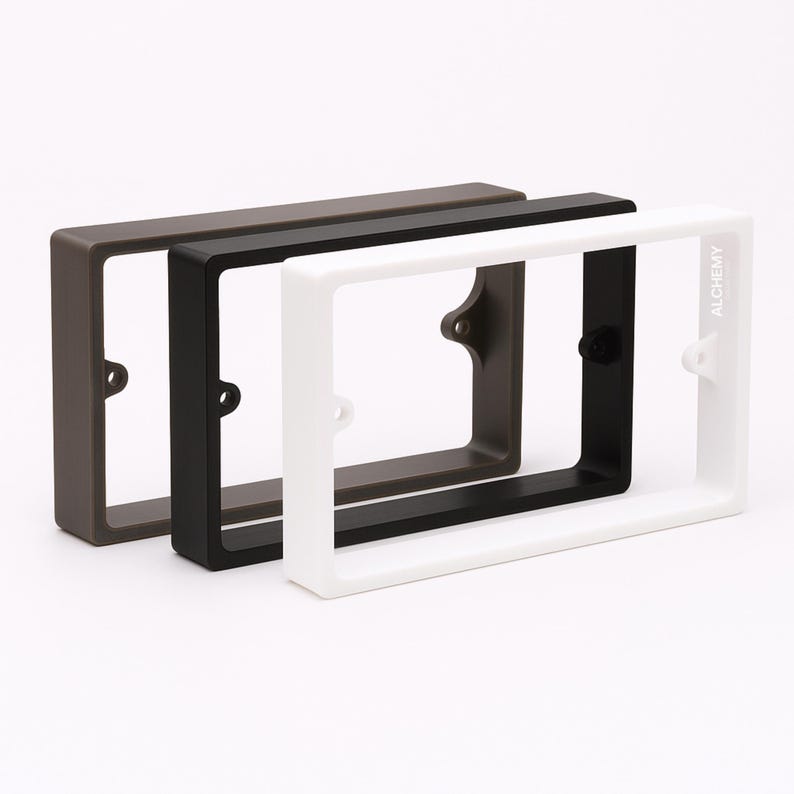 May include: Three rectangular frames in brown, black, and white. The white frame has the word "ALCHEMY" printed on the side. Each frame has mounting holes on the back.