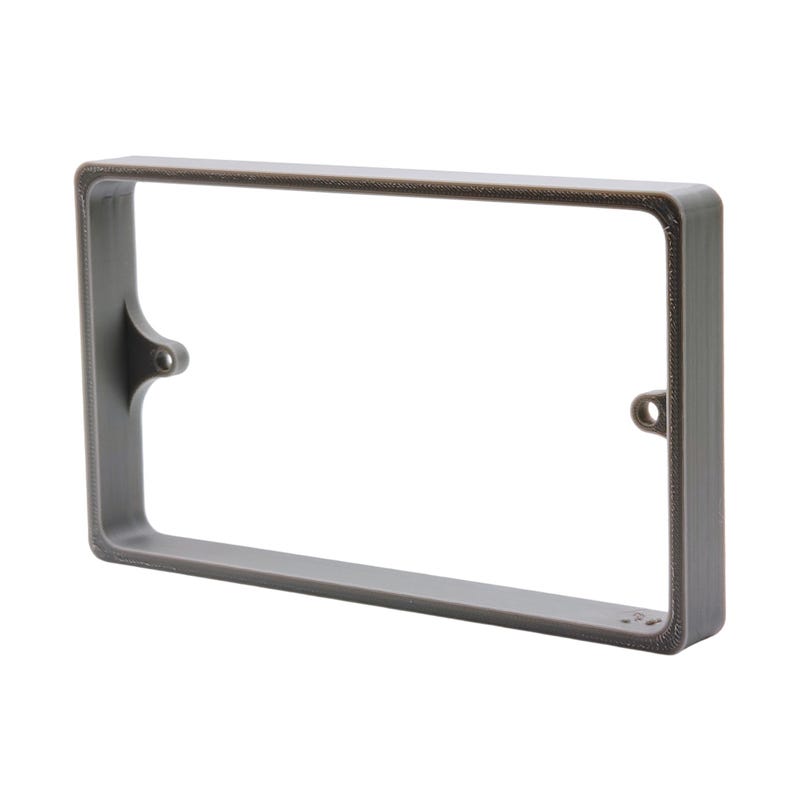 May include: A rectangular, gray frame with rounded corners and a hollow center. The frame has a textured surface and small holes on the sides for mounting. The top edge has a darker, bronze-colored trim. The frame is designed to hold a rectangular object.