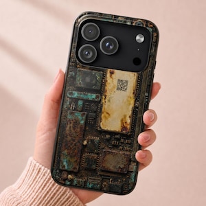 May include: A smartphone case featuring a printed design of a weathered, rusted circuit board with oxidized copper-green and brown tones. The design includes a central rectangular area with a small QR code and intricate electronic component details.