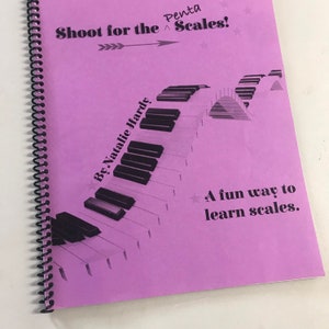 Puede incluir: Un libro morado con encuadernaci&oacute;n en espiral titulado "Shoot for the Penta Scales!" de Natalie Hardy. La portada presenta un dise&ntilde;o de teclado de piano en blanco y negro con el texto "A fun way to learn scales."