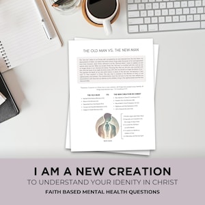 Puede incluir: Una pila de papeles blancos con el título "THE OLD MAN VS. THE NEW MAN" y texto. Debajo, se muestra el texto "I AM A NEW CREATION". También se ven una taza de café, un bolígrafo y un teclado.