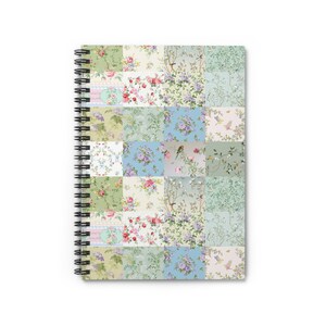 Op de afbeelding: Spiraalgebonden notitieboek met een patchworkontwerp van bloemen- en botanische patronen in roze, groen, blauw en crème. De kaft toont een collage van bloemenprints in vintage-stijl. De spiraalbinding is zwart.