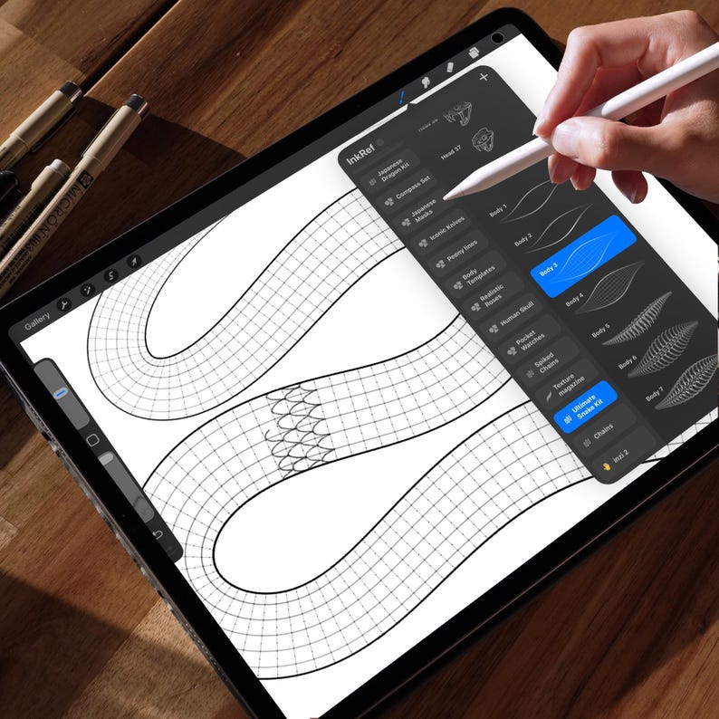 May include: A digital drawing of a snake on a tablet screen, with a hand using a stylus. The screen shows a grid pattern and drawing tools. The app name "InkRef" is visible.