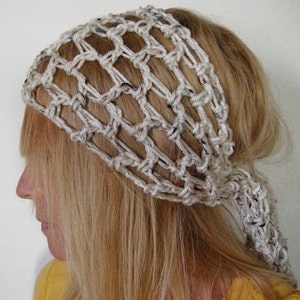 Könnte beinhalten: Ein weißes gehäkeltes Stirnband mit einem geknoteten Design. Das Stirnband wird von einer Person mit langen blonden Haaren getragen.
