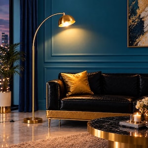 May include: A tall, arched floor lamp with a brushed gold finish and a dome-shaped shade. The lamp features a slender vertical pole, a circular base, and a curved arm that extends to position the light source directly over the seating area.