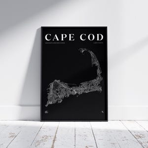 Puede incluir: Un mapa en blanco y negro enmarcado de Cape Cod, Massachusetts. El mapa es un contorno detallado de la península, con las palabras "CAPE COD" en la parte superior. El mapa se muestra en una pared blanca y un suelo de madera blanco.