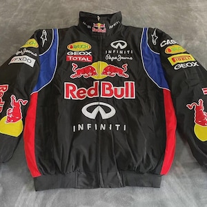 Peut inclure: Veste de course noire avec logos Red Bull et Infiniti. Comprend des accents rouges, bleus et jaunes, avec des logos de sponsors comme Pepe Jeans et Geox. La veste a une fermeture éclair complète et un col montant.