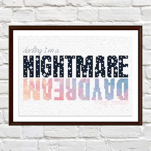 Pode incluir: Impressão artística emoldurada com as palavras "darling i'm a NIGHTMARE" em letras pixeladas azul escuro com estrelas brancas. Abaixo, a palavra "DAYDREAM" é refletida em um gradiente de rosa, laranja e azul. A impressão está em uma moldura marrom escura.