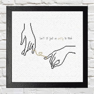 May include: Black framed art print featuring a cross-stitch design of two hands connected by a gold thread. The text "isn't it just so pretty to think" is above the hands.