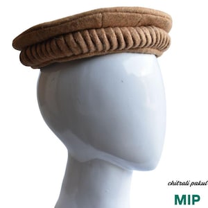 May include: A brown felt pakul hat with a folded brim. The hat is on a white mannequin head.