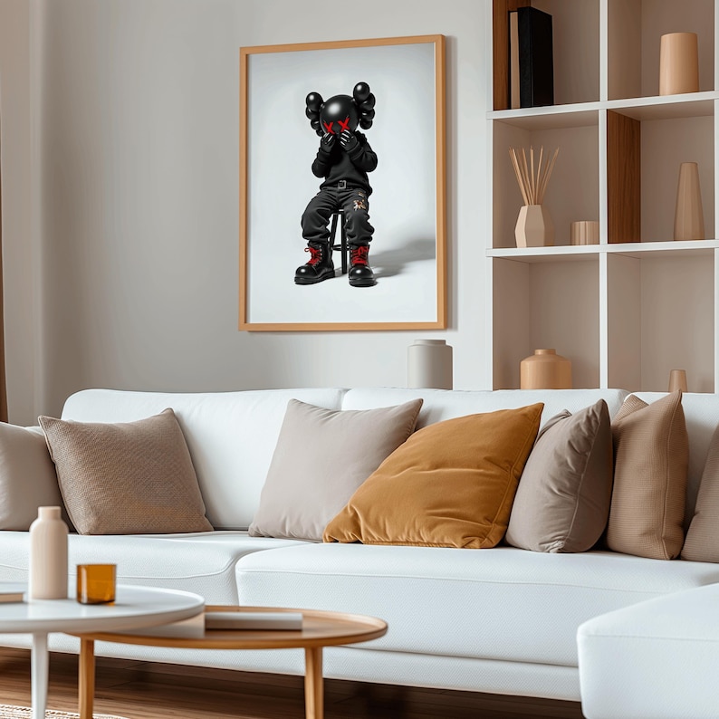 May include: A framed print of a black and red cartoon character sitting on a stool. The character has a black hoodie and black pants with red accents. The character's eyes are covered with red X's.