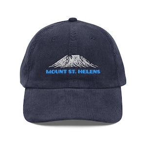 May include: Navy blue corduroy baseball cap with the embroidered text "MOUNT ST. HELENS" in blue, and a white mountain graphic. The cap has a curved brim and an adjustable strap.