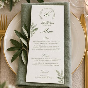 Può includere: Un cartoncino rettangolare bianco per menu con un logo a corona botanica, le iniziali A e C, i nomi Camilla e Alessandro e la data 05.09.2026. Il menu elenca le portate ed è decorato con illustrazioni di foglie verdi stampate sul bordo.