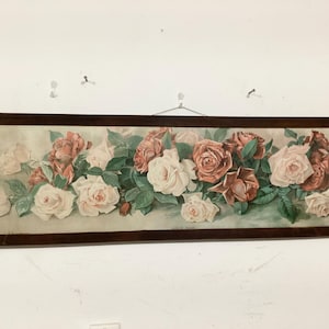 May include: A framed floral print featuring a vibrant arrangement of roses in shades of pink, white, and red. The roses are set against a soft green background with dark green leaves. The frame is a dark brown color.