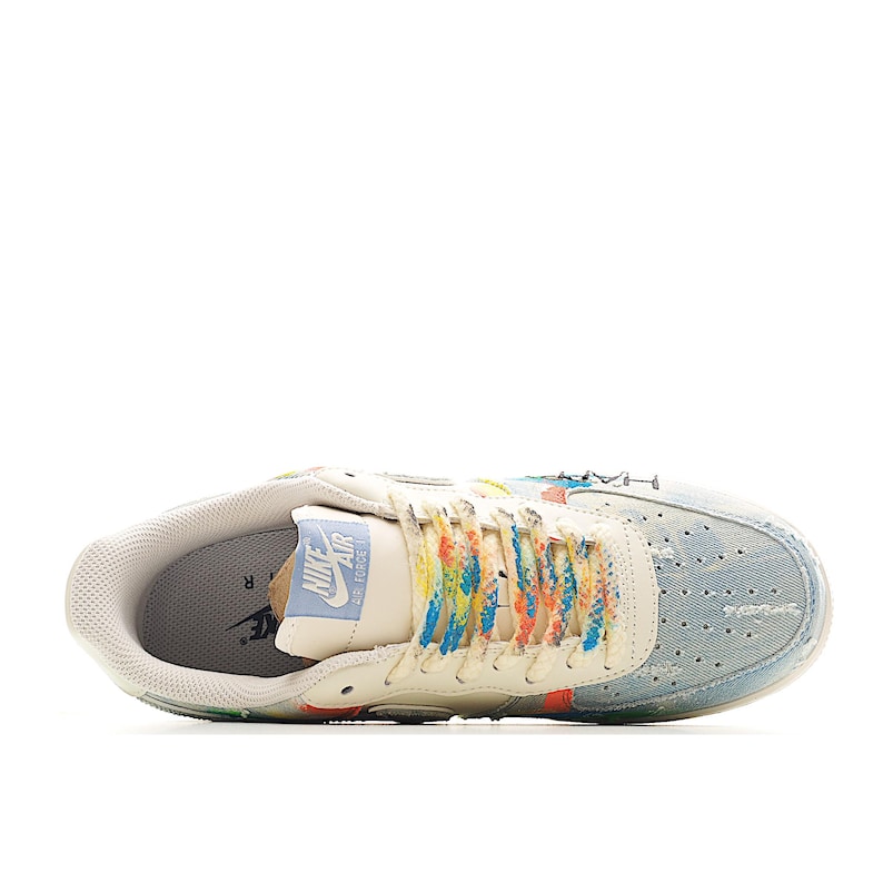 Puede incluir: Zapatilla Nike Air Force 1 color crema con puntera de mezclilla y cordones coloridos. La zapatilla presenta una etiqueta en la leng&uuml;eta azul claro con el logotipo de Nike Air Force. El dise&ntilde;o incluye detalles en naranja y azul.
