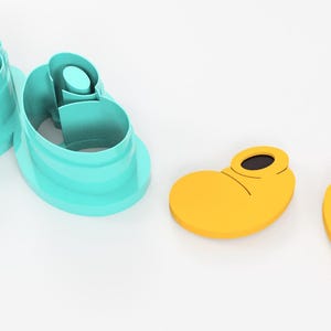 May include: A set of two teal shoe-shaped cookie cutters and two yellow shoe-shaped cookie cutters with black details. The cutters are designed to create cookies in the shape of cartoon shoes.