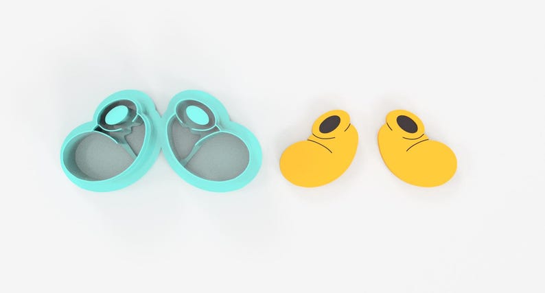 May include: A set of two teal-colored cookie cutters in a heart shape, and two yellow cookie cutters shaped like cartoon shoes. The cookie cutters are made of plastic and are on a white background.