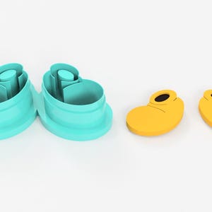 May include: A set of two teal shoe-shaped cookie cutters and two yellow shoe-shaped cookie cutters with black details. The cutters are designed to create whimsical treats.