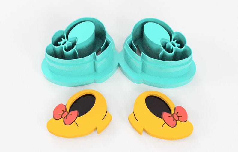 May include: Two sets of cookie cutters. The top set is teal, shaped like a shoe. The bottom set is yellow with a red bow, also shaped like a shoe. The cookie cutters are for making cookies.