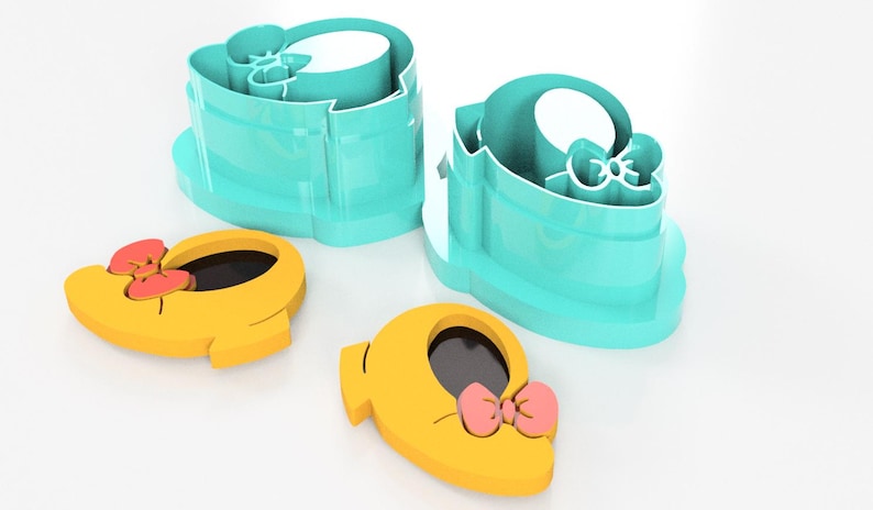 May include: A set of turquoise cookie cutters shaped like a baby shoe with a bow, alongside two yellow cookie cutouts with pink bows. The cutters are designed for baking and crafting.