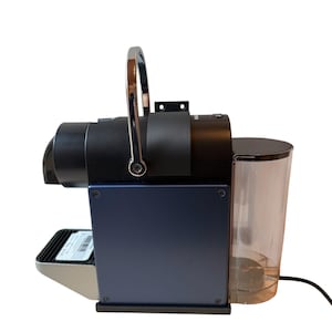 Op de afbeelding: Een moderne espressomachine met een marineblauwe en zwarte afwerking. Het heeft een zilveren handvat, een transparant waterreservoir en een kleine lekbak. De machine is ontworpen voor koffiepads.