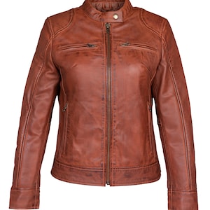 Puede incluir: Chaqueta de cuero marrón con cuello alzado y cremallera completa. La chaqueta tiene dos bolsillos en el pecho con cremallera y dos bolsillos laterales. El cuero tiene un aspecto envejecido, lo que le da un aspecto vintage. Las mangas tienen puños abotonados.