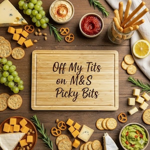 Può includere: Un tagliere in legno con il testo "Off My Tits on M&S Picky Bits" circondato da vari snack. Gli snack includono formaggio, cracker, uva, pretzel, salse e grissini. La disposizione è su una superficie di legno.