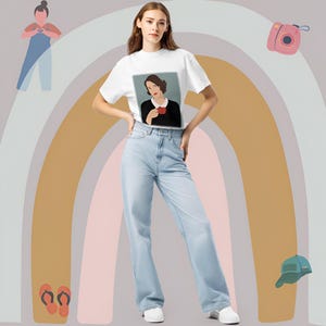 May include: A white t-shirt with a graphic print of a woman holding a red cup. The woman is wearing a white collared shirt and has dark hair. The t-shirt is being modeled by a person wearing light blue jeans.