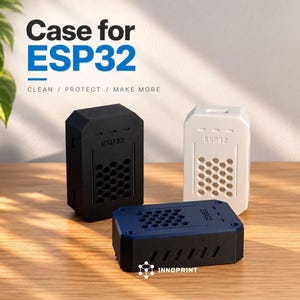 Pode incluir: Três caixas protetoras retangulares para placas de desenvolvimento ESP32 nas cores preta, branca e azul escura. Cada caixa apresenta um padrão de ventilação em favo de mel, uma abertura superior e o texto ESP32 em relevo na frente.