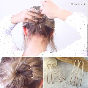 May include: Three gold hair pins with a curved shape. The pins are shown on a wooden surface. A woman is shown in the image with her hair pulled back in a bun, secured with the gold hair pins.