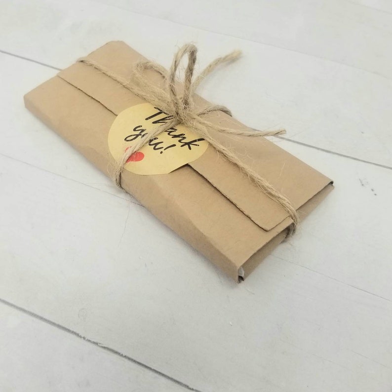 May include: A brown paper package tied with twine and a yellow circle sticker that says "Thank you!"
