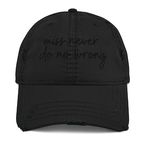Puede incluir: Gorra de béisbol negra desgastada con el texto "miss never do no wrong" bordado en blanco.