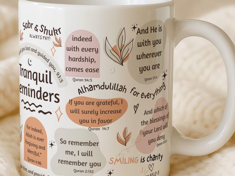 May include: White ceramic mug with inspirational quotes and floral accents. The mug features phrases like "Tranquil reminders" and "Alhamdulillah for everything" in a mix of fonts and colors. A perfect gift for anyone.