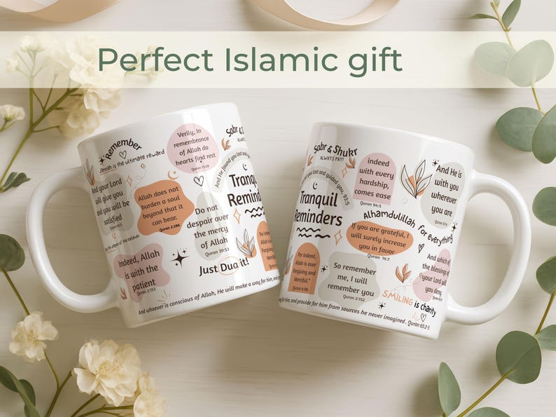 May include: Two white ceramic mugs with inspirational quotes and floral designs. The mugs feature phrases in English and Arabic, with a handle on the side. The mugs are a perfect Islamic gift.