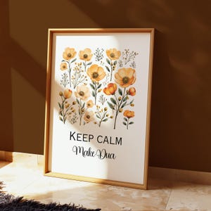 May include: A framed art print featuring a watercolor floral design with orange and yellow flowers and green foliage. The print includes the text "KEEP CALM Make Dua" in black script.