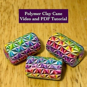 Puede incluir: Tres bastones de arcilla polimérica con patrones geométricos multicolores, incluyendo verde, rosa y azul. Los bastones son rectangulares y están sobre una superficie de madera. El texto en la parte superior dice "Polymer Clay Cane Video and PDF Tutorial."
