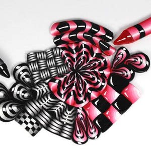 Könnte beinhalten: Eine Ansammlung farbenfroher, abstrakter Kunstwerke. Die Sammlung umfasst einen schwarz-silbernen Stift, einen rosa-schwarzen Buntstift und mehrere gemusterte Formen in Schwarz, Weiß und Rosa. Die Designs zeigen Streifen, Schachbretter und Blumenmuster.