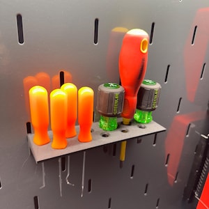 May include: A black tool organizer with four orange and yellow screwdrivers and three green and black screwdrivers with the text "GREENLEE" on them.