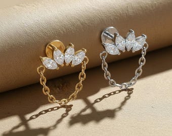 May include: Two stud earrings with a chain design. One earring is gold-toned, and the other is silver-toned. Each earring features a cluster of five clear, marquise-cut stones above a chain that forms a small loop.