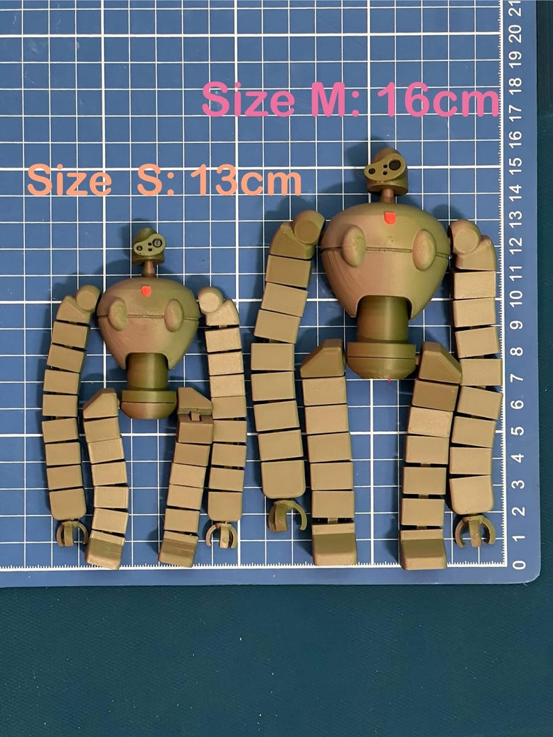 K&ouml;nnte beinhalten: Zwei zerlegte Roboter-Spielzeuge, eines braun und eines gr&uuml;n, mit segmentierten Gliedma&szlig;en. Der gr&ouml;&szlig;ere Roboter ist 16 cm gro&szlig; und der kleinere 13 cm.  Gr&ouml;&szlig;e S: 13 cm Gr&ouml;&szlig;e M: 16 cm